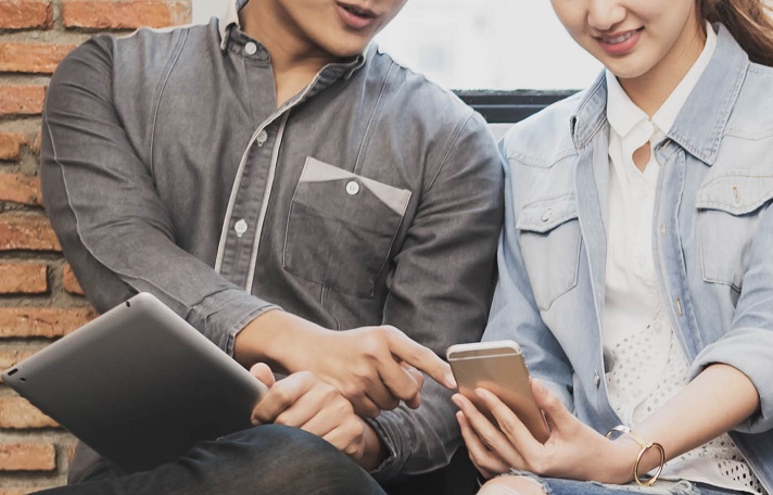 two epople looking at tablet and mobile